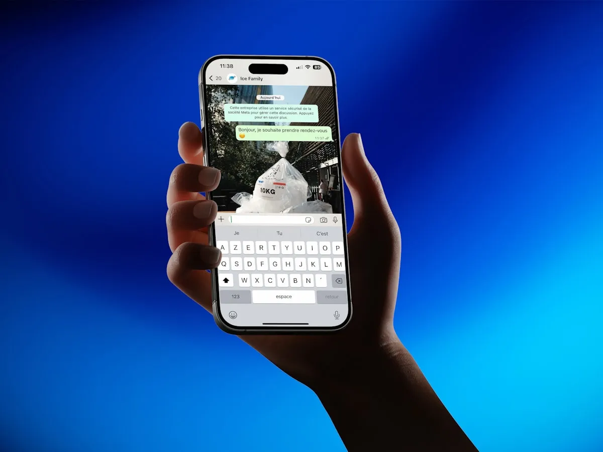Hand holding a smartphone with a messaging app open