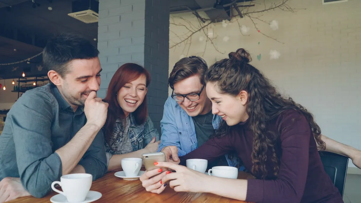 Group of young friends laughing together while sharing a smartphone in a cafe