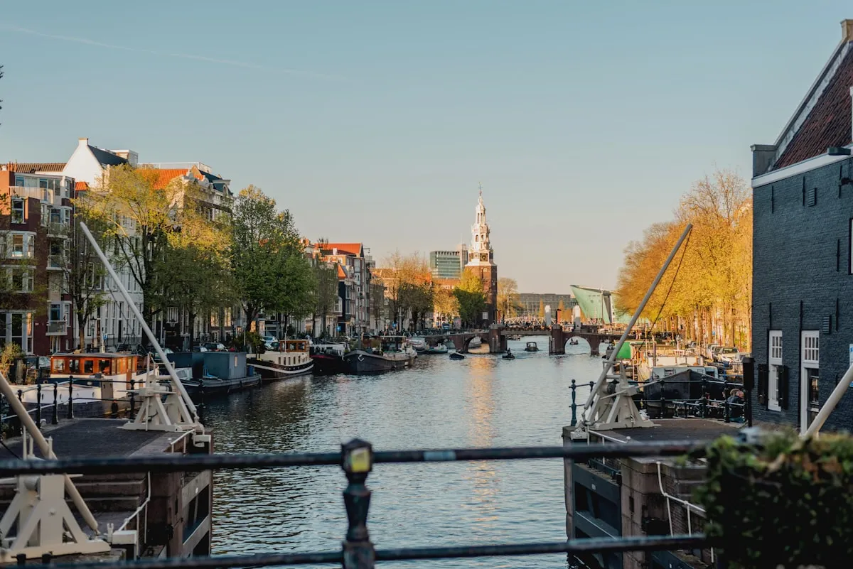 Amsterdam canal houses reflected in the water at sunset, bridges crossing between them